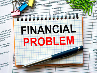 Notepad with text Financial Problem on white background with paper clips and pen