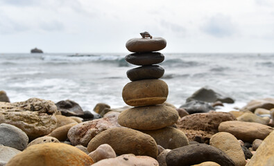 una torre de piedras redondas en una playa del mediterraneo
