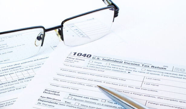 US tax form 1040 with a silver pen and glasses