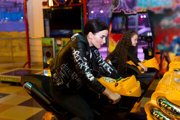 Fototapeta na wymiar Mother and daughter playing slot machines, motorcycle racing