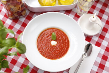 
Tomato soup with basil and cream.
Suggestion to serve a dish. Food background.