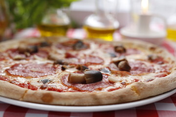 Pizza with salami and mushrooms. Italian cuisine.
Traditional Italian pizza. Suggestion to serve a dish. Food background.
