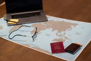 table with world map and laptop and passport