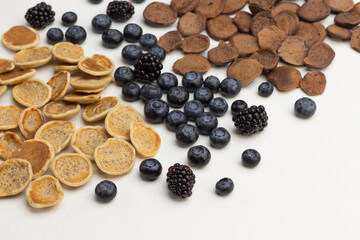 Mini pancakes and berries on white background.