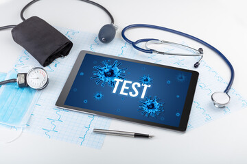 Tablet pc and doctor tools on white surface with TEST inscription, pandemic concept