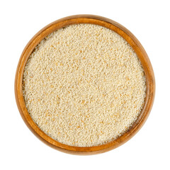 Fine breadcrumbs in a wooden bowl. Dry bread crumbs, known as breading or crispies, are sliced ​​residue of dry bread, used for breading or crumbing foods. Close-up from above, over white, food photo.