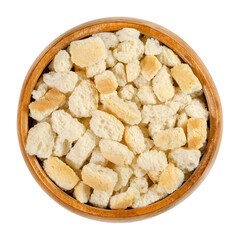 Dry bread cubes for stuffing, in a wooden bowl. Made of rolls, cut into cubes and dried, used for bread stuffing recipes like bread dumplings or stuffed turkey. Close-up, from above, macro food photo.