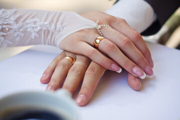 groom embraces the bride with wedding bouquet. rings on the hands of newly-married couple. bride put her hands on the shoulders of the bridegroom.