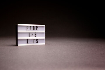 Light up sign shot in studio with copy space that says Stop The Lies.