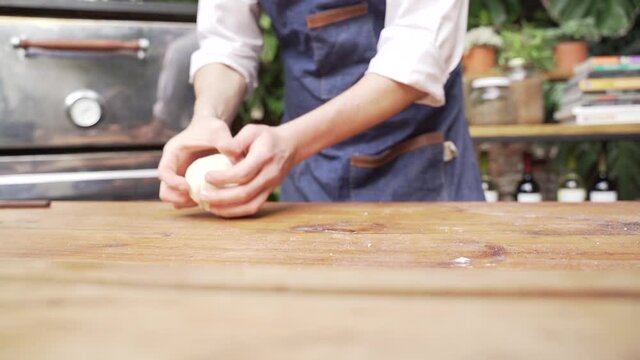 Chef preparando la masa para pizza en una cocina al aire libre