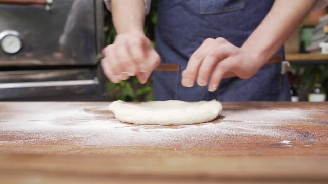 Chef preparando la masa para pizza en una cocina al aire libre 