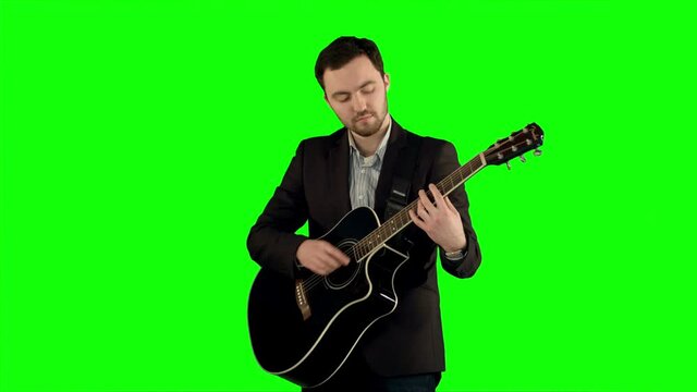Young man playing guitar on a Green Screen