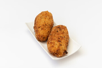 Plato pequeño con dos croquetas caseras sobre fondo blanco.