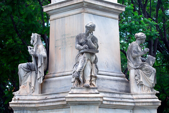 Marble statues on the base of the statue of Ioannis Varvakis in the garden of the Zappeion Palace of Athens, Greece.