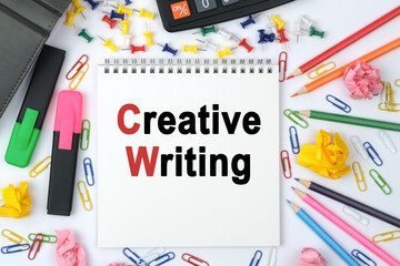 On the table is a calculator, diary, markers, pencils and a notebook with the inscription - Creative writing