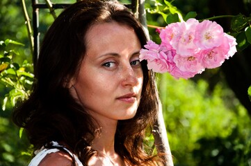 Naklejka premium Beautiful girl with flowers. Woman hold roses closeup. adorable lady with roses. Vintage spa concept. portrait of young beautiful woman with rose. beauty girl. tender and soft. pretty girl portrait