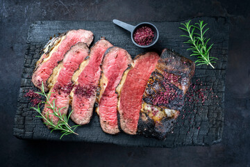 Traditional Commonwealth Sunday roast with sliced cold cuts roast beef with herbs and salt as top...