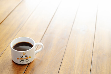 coffee cup on a wooden table with a message of enjoy every moment it is summer time background