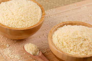 Wooden bowls of Grated Parmesan Cheese on a wooden background