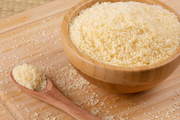 Wooden bowls of Grated Parmesan Cheese on a wooden background