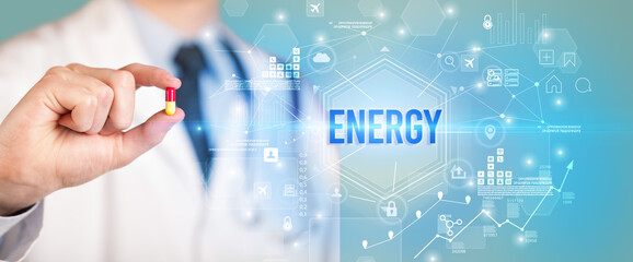 Doctor giving a pill with ENERGY inscription, new technology solution concept