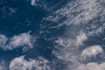 several layers of white clouds floating together under the blue sky.