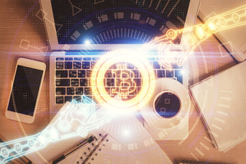 Blockchain theme hologram drawings over computer on the desktop background. Top view. Double...