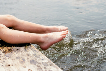 Children's feet close up splashing in the water.Summer concept. Happy childhood concept.Copy space for text