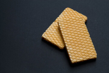 Two delicious strawberry flavor wafer cookies on black background.