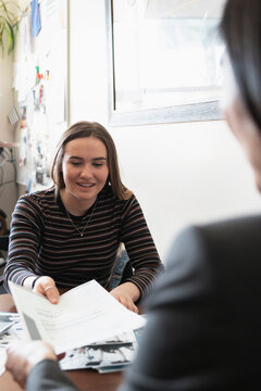 Counselor Showing College Acceptance Letter To High School Student