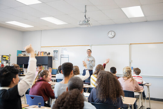 High school teacher calling on students in classroom