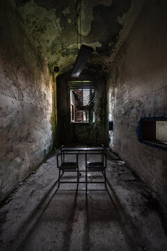 A school desk in a narrow classroom of an abandoned madhouse