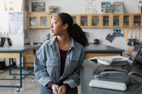 Thoughtful high school girl student looking away in classroom