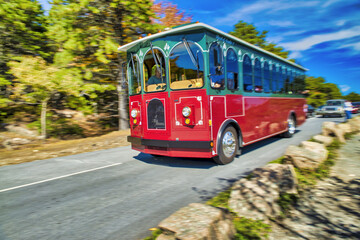 Speeding up red trolley in Acadia National Park, Maine