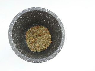 grinding oregano with stone mortar