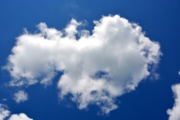 Naklejka na ściany i meble Beautiful white cloud on a blue sky, horizontal photo.