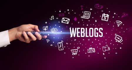 hand holding wireless peripheral with WEBLOGS inscription, social media concept