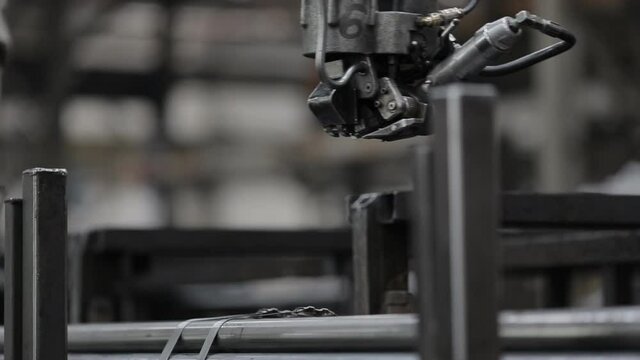 Manufacture of steel products. Tube rolling plant. The packer straps the pipes with metal tape