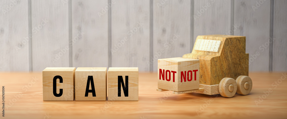 Wall mural wooden forklift is transporting off a cube to alter a message from can not to can on wooden backgrou