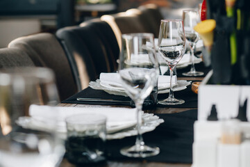 tableware Glasses, flower fork, knife served for dinner in restaurant with cozy interior