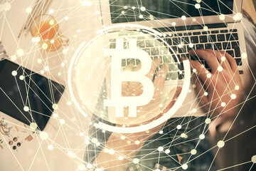 Double exposure of man's hands typing over computer keyboard and crypto currency theme hologram drawing. Top view. Blockchain concept.