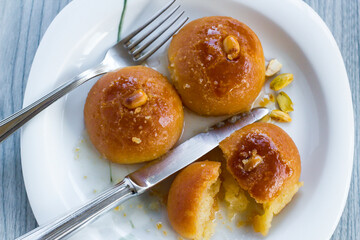 Traditional Turkish Baked Pastry, "Sekerpare" with cutlery set on the wooden table.Ramadan or Feast Desserts.