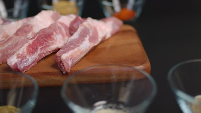 Close-up raw ribs on a wooden cutting board with marinating in 4K.