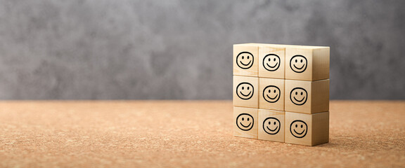 cubes with happy emoticons on cork surface and concrete background