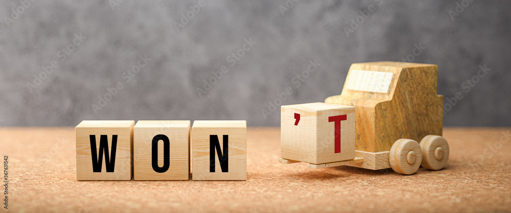 Wall mural wooden forklift is transporting off a cube to alter a message from won't to won on cork surface and 