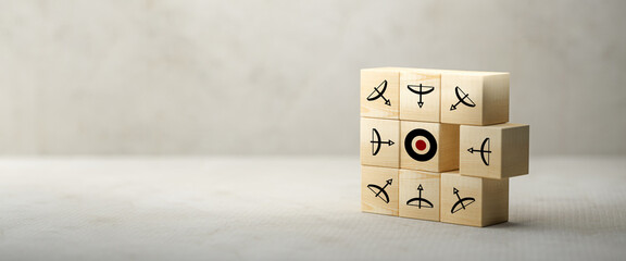 cubes with bow and arrow symbols all pointing into the middle to an target symbol on paper surface...