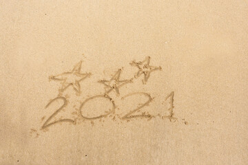 Hand written sign on a yellow warm sand three stars and 2021 year