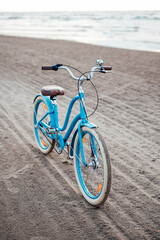 Fototapeta premium Light-blue bicycle on the beach with the sea on the background