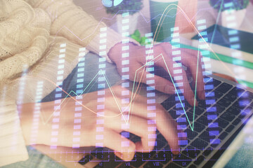 Double exposure of woman hands typing on computer and forex chart hologram drawing. Stock market invest concept.