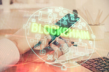 Double exposure of man's hands holding and using a phone and crypto currency blockchain theme...